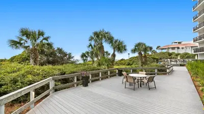 a balcony with a table and chairs on a boardwalk at One Seagrove Place 0207 in Santa Rosa Beach