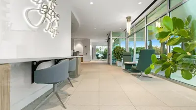 an office lobby with green chairs and plants at One Seagrove Place 0207 in Santa Rosa Beach