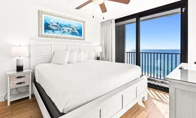 a white bedroom with a bed and a balcony at One Seagrove Place 1204 in Santa Rosa Beach