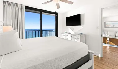 a white bedroom with a bed with a view of the ocean at One Seagrove Place 1204 in Santa Rosa Beach