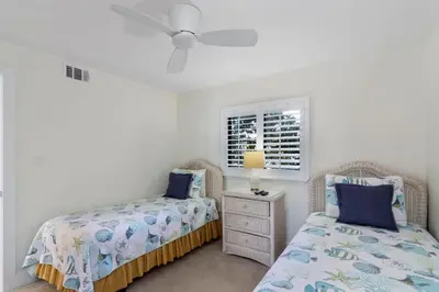 a bedroom with two beds and a dresser and a window at One Seagrove Place 0208 in Santa Rosa Beach