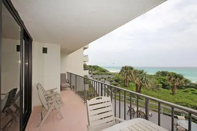a balcony with chairs and a view of the ocean at One Seagrove Place 0208 in Santa Rosa Beach