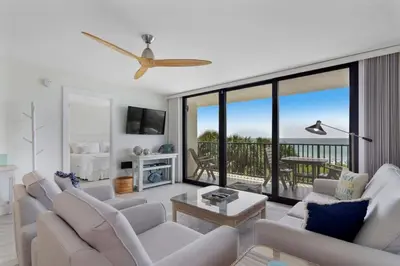 a living room with white furniture and a balcony at One Seagrove Place 0208 in Santa Rosa Beach