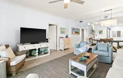 a living room with a tv and a couch and chairs at High Pointe Resort 232 in Santa Rosa Beach