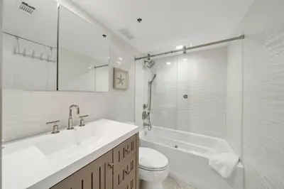 a white bathroom with a sink and a tub and a toilet at One Seagrove Place 0305 in Santa Rosa Beach