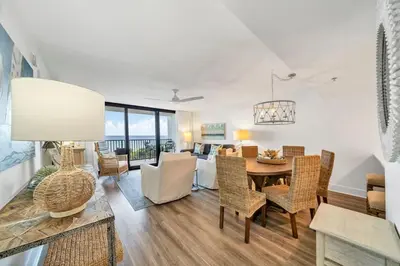 a dining room and living room with a table and chairs at One Seagrove Place 0305 in Santa Rosa Beach