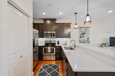 a kitchen with white counter tops and wooden cabinets at SunDune on 30A in Santa Rosa Beach