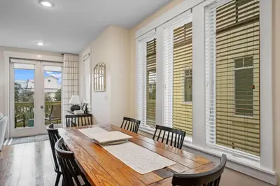 a dining room with a table and chairs and windows at SunDune on 30A in Santa Rosa Beach