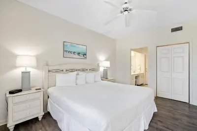 a white bedroom with a large bed and a ceiling fan at High Pointe Resort 131 in Inlet Beach