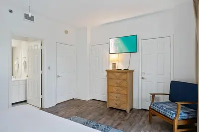 a bedroom with a bed and a chair and a television at High Pointe Resort 131 in Inlet Beach
