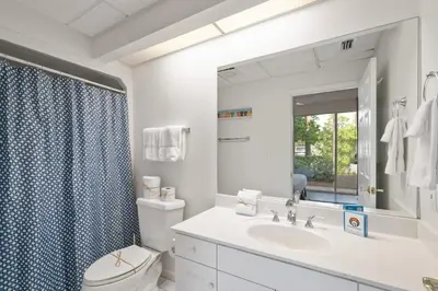a bathroom with a toilet and a sink and a mirror at High Pointe Resort 131 in Inlet Beach