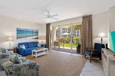 a living room with a blue couch and a tv at High Pointe Resort 131 in Inlet Beach