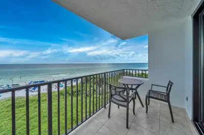 a balcony with a table and chairs and a view of the beach at One Seagrove Place 0402 in Santa Rosa Beach