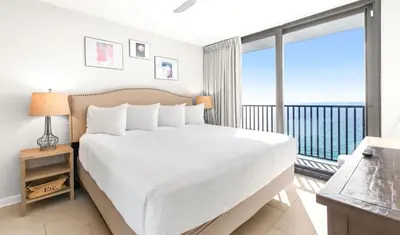 a bedroom with a large white bed and a balcony at One Seagrove Place 1603 in Santa Rosa Beach