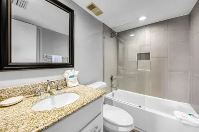 a bathroom with a sink and a toilet and a mirror at One Seagrove Place 1603 in Santa Rosa Beach