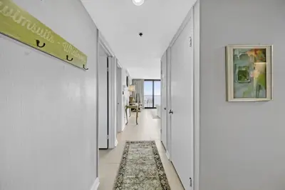 a hallway with white walls and a rug at One Seagrove Place 1603 in Santa Rosa Beach
