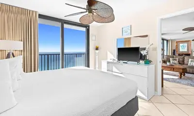 a bedroom with a white bed and a television at One Seagrove Place 1703 in Santa Rosa Beach