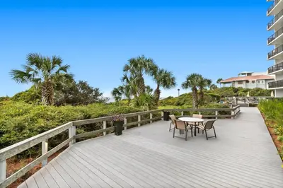a boardwalk with a table and chairs on it at One Seagrove Place 1806 in Santa Rosa Beach