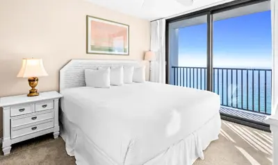 a white bedroom with a bed and a balcony at One Seagrove Place 2106 in Santa Rosa Beach