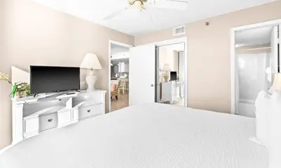 a white bedroom with a large bed and a flat screen tv at One Seagrove Place 2106 in Santa Rosa Beach