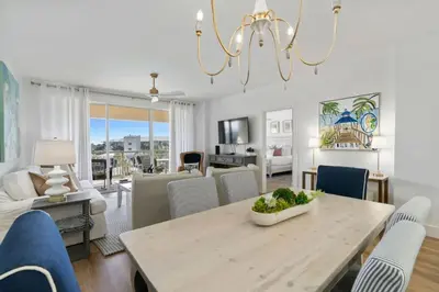 a dining room and living room with a table and chairs at High Pointe Resort 432 in Inlet Beach