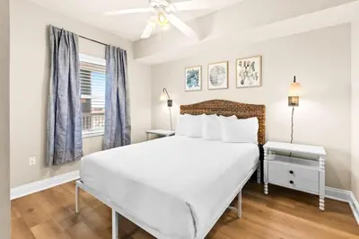 a white bedroom with a large bed and a window at Palazzo 0507 in Panama City Beach