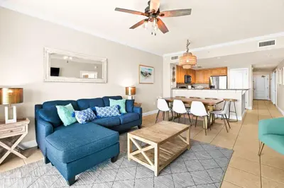 a living room with a blue couch and a table at Palazzo 0507 in Panama City Beach