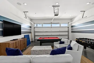 a living room with couches and a pool table at Laguna Loafin' in Panama City Beach