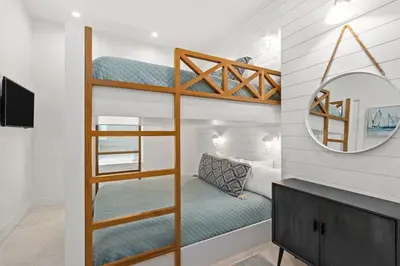 a bedroom with bunk beds and a mirror at Laguna Loafin' in Panama City Beach