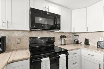 a kitchen with a black stove and a microwave at One Seagrove Place 0408 in Santa Rosa Beach