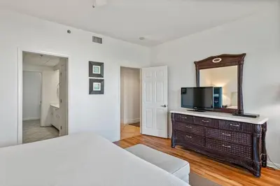 a bedroom with a television on a dresser with a mirror at High Pointe Resort E26 in Inlet Beach