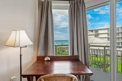 a desk in front of a window with a view of the ocean at High Pointe Resort E26 in Inlet Beach