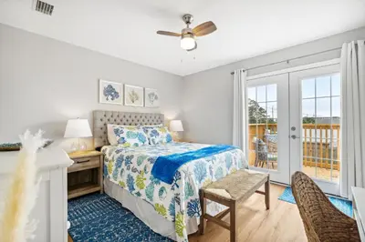 a bedroom with a bed and a desk and a window at Coastal Retreat by the Beach in Panama City Beach