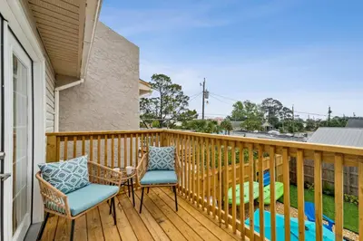 a balcony with two chairs and a table at Coastal Retreat by the Beach in Panama City Beach