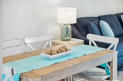 a living room with a table and a couch at Coastal Retreat by the Beach in Panama City Beach