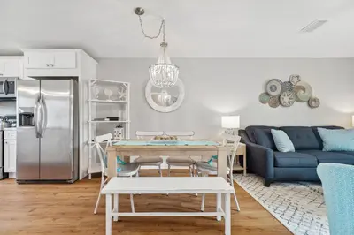 a kitchen and living room with a table and a couch at Coastal Retreat by the Beach in Panama City Beach