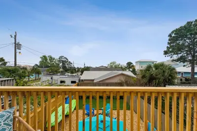 a deck with chairs and a view of a neighborhood at Coastal Retreat by the Beach in Panama City Beach