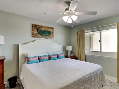 a bedroom with a white bed with a ceiling fan at Emerald Beach #1333 in Panama City Beach