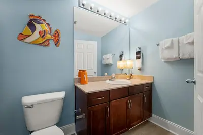 a bathroom with a toilet and a sink and a mirror at Laketown Wharf #1433 in Panama City Beach