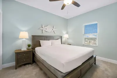 a bedroom with a bed and a ceiling fan at Laketown Wharf #1510 in Panama City Beach