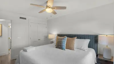 a white bedroom with a bed with a ceiling fan at Mistral 12 in Seacrest