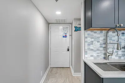 a kitchen with a sink and a white door at Newly Completely Renovated Beach Condo at Sunbird Resort! Free Beach Chair and Umbrella Service! by Dolce Vita Getaways! in Panama City Beach