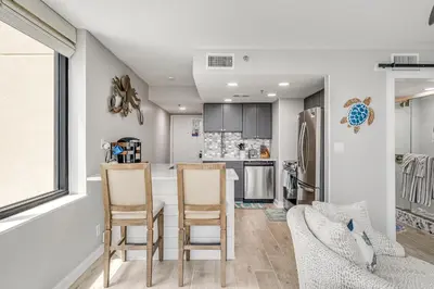 a kitchen with a table and chairs and a refrigerator at Newly Completely Renovated Beach Condo at Sunbird Resort! Free Beach Chair and Umbrella Service! by Dolce Vita Getaways! in Panama City Beach