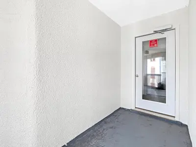 a white room with a door with a sign on it at Charming Beach Studio With Pool & Sauna in Panama City Beach