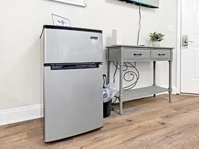 a refrigerator in a room next to a table at Charming Beach Studio With Pool & Sauna in Panama City Beach