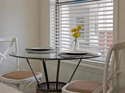 a glass table with plates on it next to a window at Charming Beach Studio With Pool & Sauna in Panama City Beach