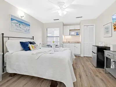 a bedroom with a bed and a kitchen at Charming Beach Studio With Pool & Sauna in Panama City Beach