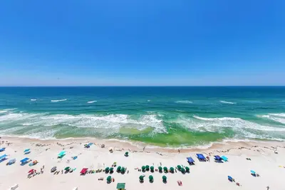 a group of people on a beach near the ocean at Emerald Isle 1504 in Panama City Beach