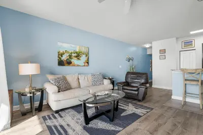 a living room with a couch and a chair at Stylish 1BD Beachfront Condo with Amenities Galore! by Dolce Vita Getaways! in Panama City Beach