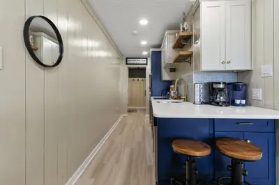 a kitchen with blue cabinets and two stools at K and J Panama City Beach in Panama City Beach